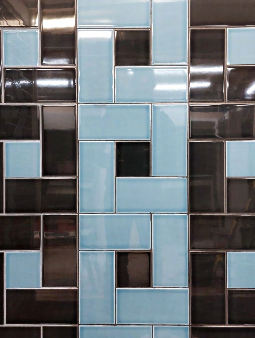 Dekoratives Mosaikmuster in Hellblau und Braun an einer Wand